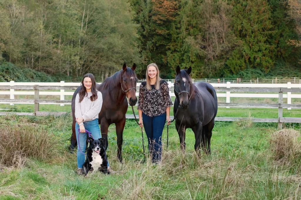 mother and daughter with two horses and dog